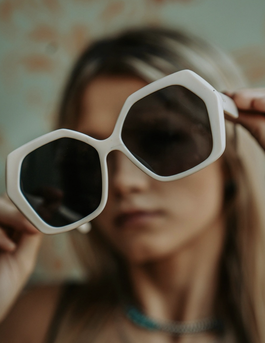 a woman show the white cat-eye sunglasses