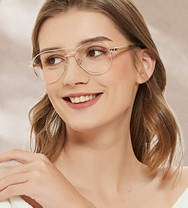 A smiling woman wearing stylish, thin-rimmed aviator glasses with a double bridge.