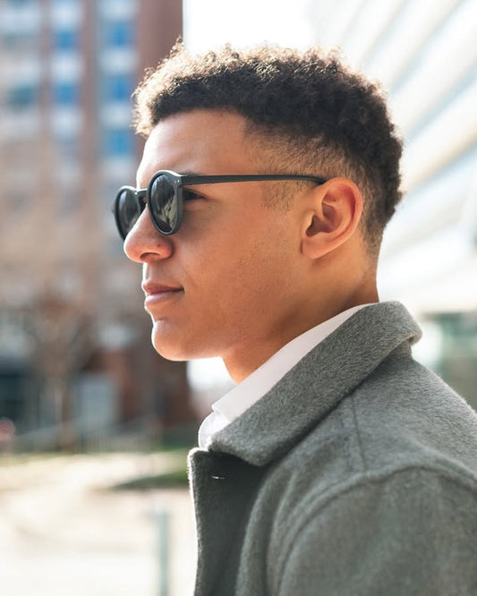Side face of a man wearing black round sunglasses