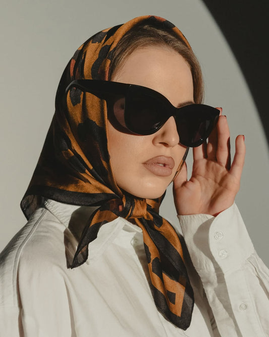 Woman wearing headscarf and dark-framed sunglasses with tinted lenses
