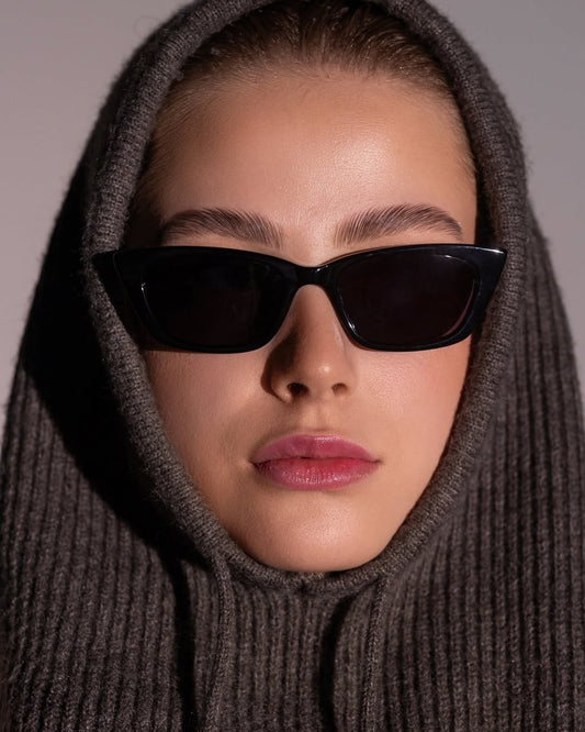 Woman in sleek black sunglasses, hood up.